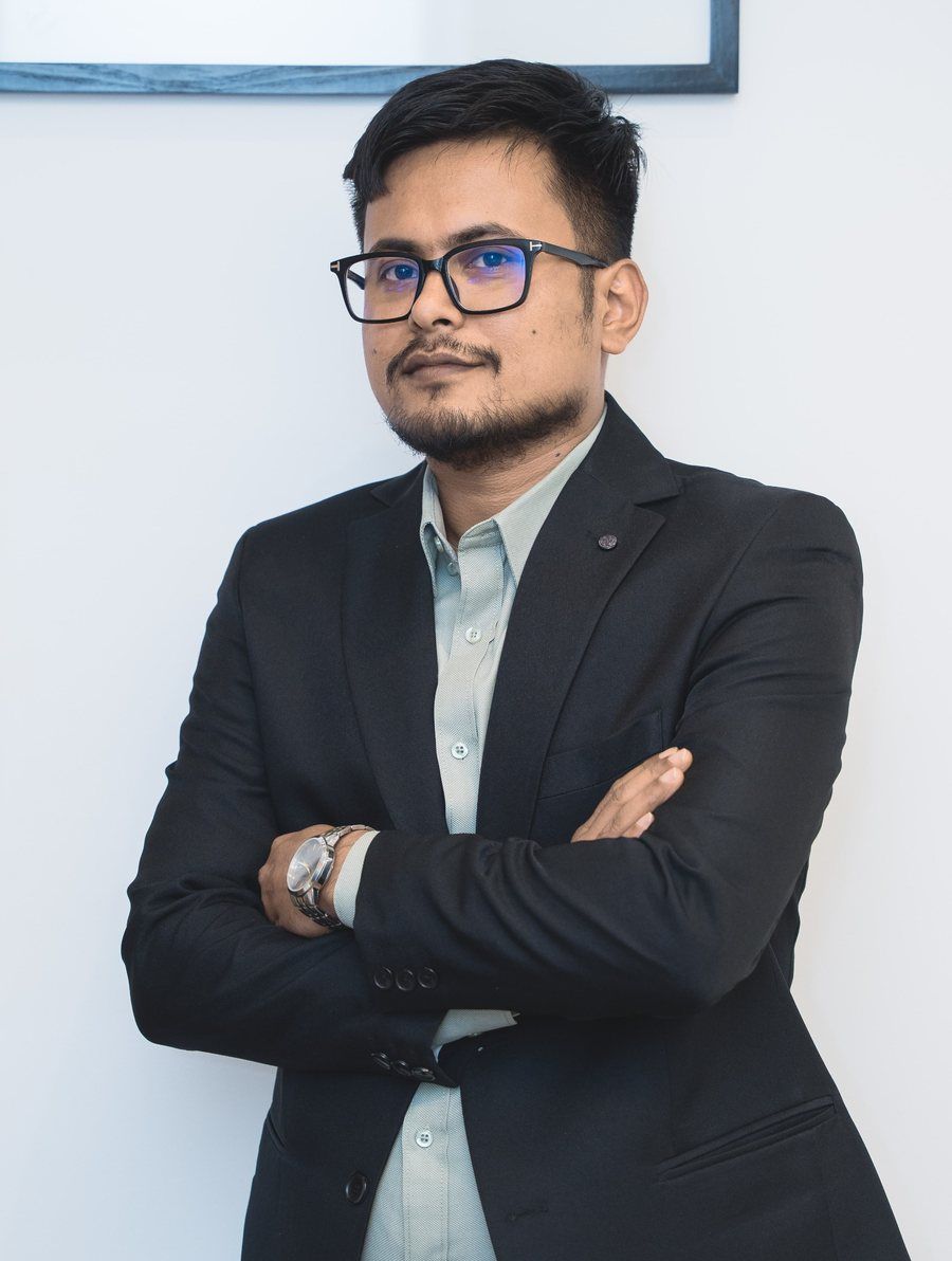 Santosh Karki, arms crossed, in a dark blazer